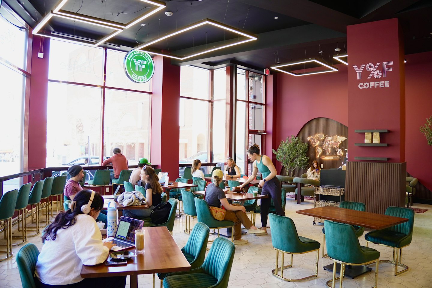 Klanten werken en socialiseren aan houten tafels in een café.